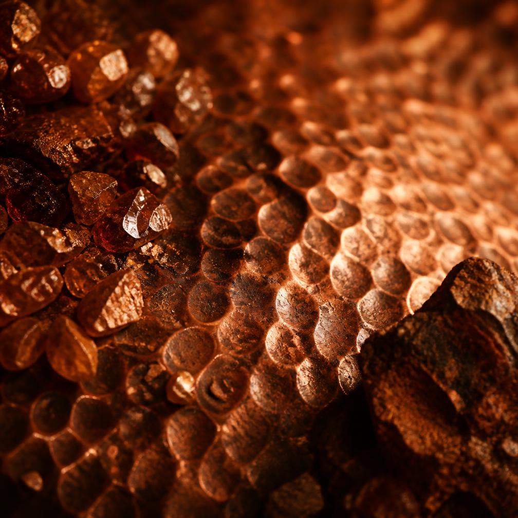 Macro detail of hammered copper texture with raw crystal fragments
